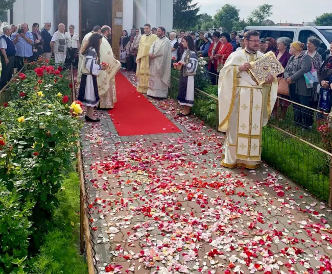 Foto OPULENŢĂ. Petale de trandafiri presărate în calea episcopului Slatinei, la Slătioara - FOTO