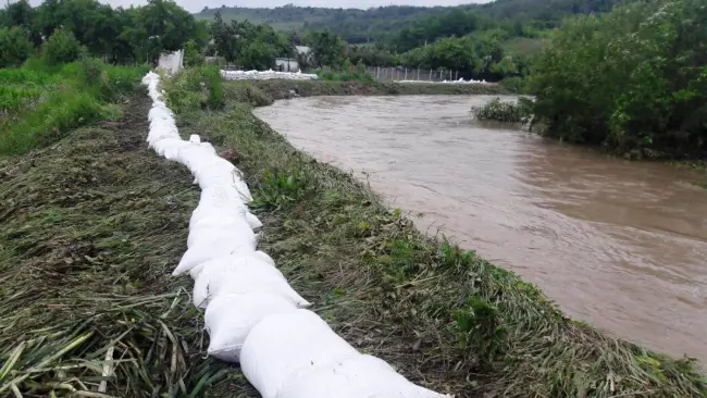 Foto FOTO&VIDEO. Dig de apărare împotriva inundaţiilor, ridicat la Teslui. Cinci gospodării sunt în pericol
