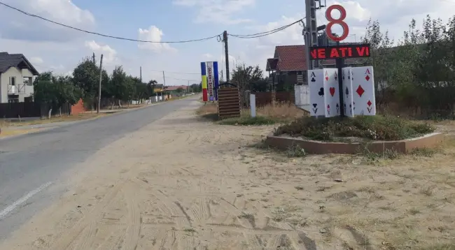 Foto Comuna „Opt-Aşi” din judeţul Olt. Un totem cu cifra 8 peste cărţi de joc imense, la intrarea în localitate - FOTO